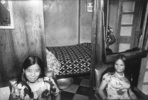 India. Una donna e una ragazza all'interno di un'abitazione - sullo sfondo la camera da letto
