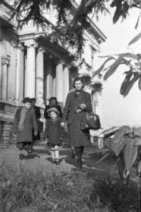 Milano dopoguerra. Signora con bambini all'uscita di un edificio pubblico dopo la visita medica