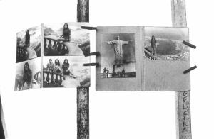 Brasile. Cartellette di cartone affisse a due paletti - su di esse sono attaccate fotografie di famiglia e fotografia della statua di Cristo Redentore di Rio de Janeiro