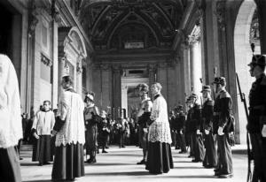 Roma - Basilica di S. Pietro. Militari in alta uniforme ed ecclesiasti schierati sotto al portico all'uscita della chiesa
