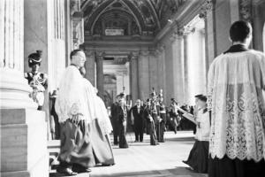 Roma - Basilica di S. Pietro. Militari in alta uniforme ed ecclesiasti schierati sotto al portico all'uscita della chiesa, con tonaca di chierichetto in primo piano