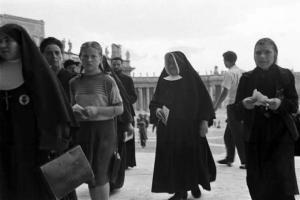 Roma - Basilica di S. Pietro. Alcuni fedeli e suore si dirigono verso l'ingresso della chiesa. Sullo sfondo la piazza