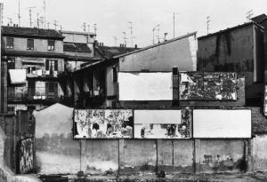 Milano - Quartiere Isola. Case di ringhiera. Muro cieco con manifesti pubblicitari strappati