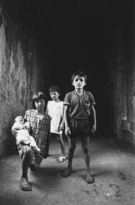 Il ventre del colera. Ercolano - Edificio fatiscente - Ritratto infantile di gruppo: ragazzina con in braccio un neonato e altri due bambini