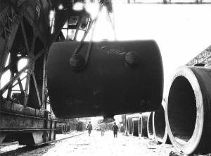 Acciaierie. Terni - Stabilimento siderurgico - Tubo sospeso tenuto da cavi d'acciaio - Operai