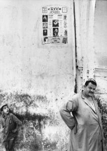 Marocco. Ritratto di un giovane e un adulto. Sul muro dietro a loro una locandina di incontro di catch