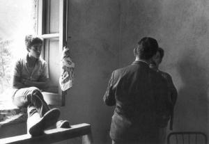 Due uomini adulti a colloquio e un ragazzino seduto sul davanzale della finestra