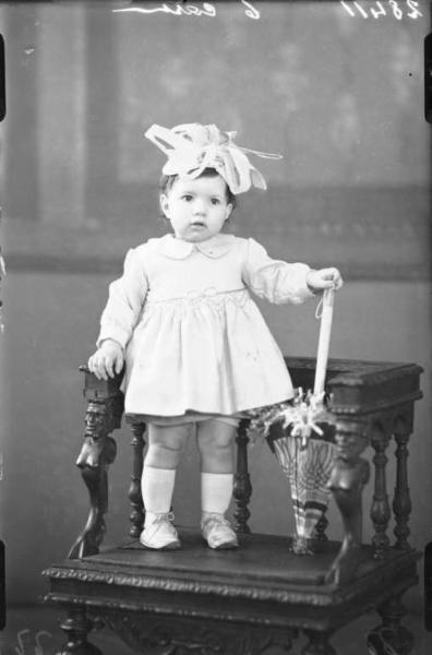 Ritratto femminile - bambina con cappellino a fiocco e ombrellino.