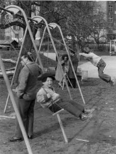 Lezione di ripresa fotografica [?] presso un parco giochi - bambini sull'altalena