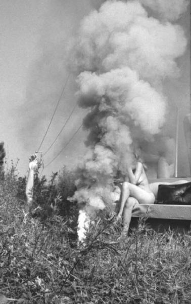 B&B Italia - set pubblicitario - nudo femminile tra complementi d'arredo tra l'erba, nuvola di fumo
