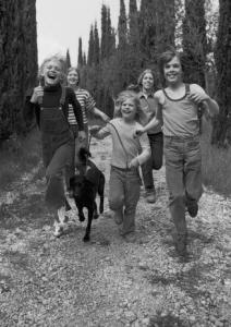 Bambini che corrono lungo una strada di campagna