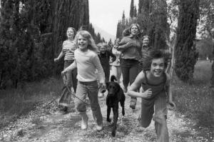 Bambini che corrono lungo una strada di campagna
