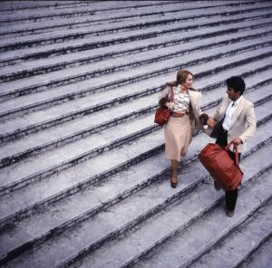 Uomo e donna scendono da una scalinata - borse