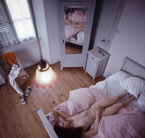 Ritratto femminile - modella nuda sul letto in una stanza ripresa dall'alto