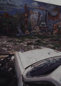 New York. Carcassa di auto davanti a un muro dipinto