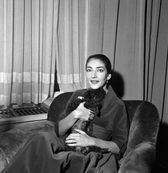 Milano - Abitazione di Maria Callas: interno - Soggiorno - Ritratto femminile: Maria Callas (cantante lirica) con cane barboncino seduta sulla poltrona