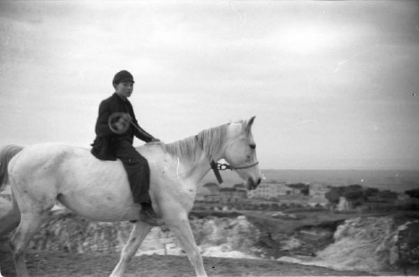 Tarquinia - Ritratto maschile: ragazzo a cavallo - Città sullo sfondo