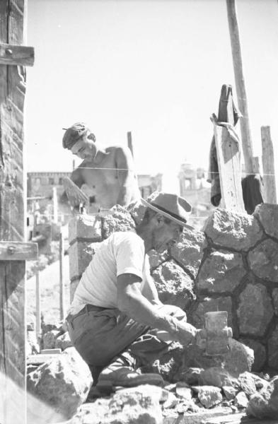 Italia Dopoguerra: Valmontone bombardata. Valmontone - Cantiere -Impalcatura - Ritratto maschile: operai al lavoro - Martello - Pietre