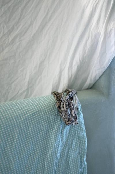 Check in': Un letto in mezzo ai fiori. Torino - Abitazione: interno - Mutande su bracciolo di un divano - Lenzuola