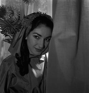 Milano - Abitazione di Maria Callas: interno - Ritratto femminile a mezzo busto: Maria Callas (cantante lirica) - Abito con cappuccio - Tenda - Fiori