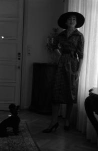 Milano - Abitazione di Maria Callas: interno - Mobili in legno - Tenda - Ritratto femminile a figura intera: Maria Callas (cantante lirica) - Cappello - Cane barboncino