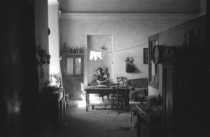 Italia Dopoguerra: Valmontone bombardata. Valmontone - Abitazione, interno: sala cucina - Ritratto femminile: donna con bambino in braccio
