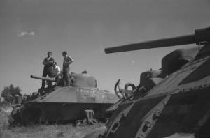 Italia Dopoguerra: Valmontone bombardata. Valmontone - Ritratto maschile di gruppo: tre uomini sopra un carro armato