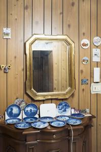 Check in': Jlicilandia's home. Torino - Abitazione: interno - Specchio - Parete in legno - Piatti in ceramica su mobiletto di legno - Modem internet