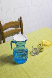 Check in': Jlicilandia's home. Torino - Abitazione: interno - Brocca, bicchieri e fette di ananas su tavolo - Schienale di una sedia