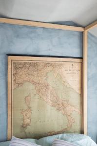 Check in': Un letto in mezzo ai fiori. Torino - Abitazione: interno - Parete con cartina del Regno d'Italia - Baldacchino in legno - Letto
