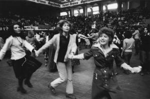 Festa al Palalido di Milano. Milano, Palalido: interno - Ritratto di gruppo: donne ballano in cerchio tenendosi per mano