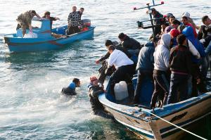 Migranti_Lampedusa. Lampedusa - Sbarco di nordafricani - Mare - Due barche - Gruppo di migranti tunisini - Ragazzi in mare