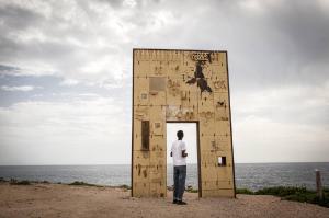 Migranti_Lampedusa. Lampedusa - Giornate dopo il naufragio del 3 ottobre 2013 - Promontorio - Monumento Porta d'Europa di Mimmo Paladino - Ragazzo migrante di spalle - Mare