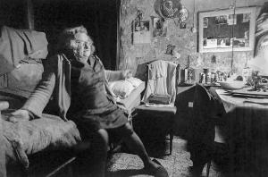 Altrove (1967-1980). Torino, Porta Palazzo - Abitazione, interno: camera da letto - Ritratto femminile: donna anziana seduta sul letto - Oggetti sacri - Degrado
