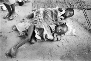 Reportage. Mozambico - Villaggio di capanne di paglia - Ritratto di bambini denutriti sdraiati per terra su stuoie - Povertà