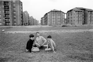 Altrove (1967-1980). Torino, quartiere Le Vallette - Periferia - Ritratto di gruppo: tre bambini seduti sul prato - Palazzi (nuove costruzioni) - Immigrazione dal sud Italia