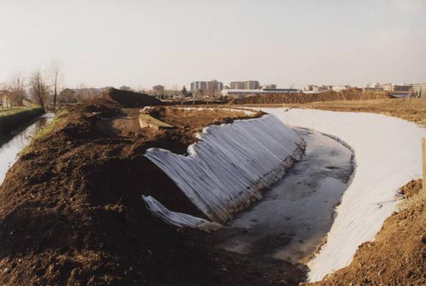 Bresso - Parco Nord, settore Montagnetta - Lavori di impermeabilizzazione del bacino di invaso - Canale Breda - Cumuli di terra - Alberi - Sullo sfondo palazzi della città
