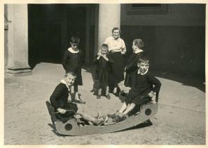 Istituto dei Ciechi di Milano - Scuola elementare - Cortile - Ricreazione - Bambini giocano con il dondolo - Maestra
