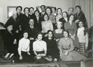 Abitazione della signora Patrizio - Interno - Ritratto di gruppo - Donne del coro (?) con due uomini - A sinistra in fondo Cornelia Panzeri