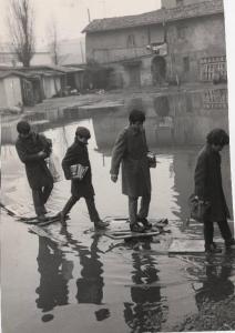 Milano - Via Crescenzago - Allagamento - Bambini attraversano l'acqua saltando su pezzi di legno con i libri di scuola sottobraccio