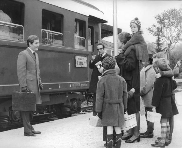 Scena del film "Tenderly" - Regia Franco Brusati - 1968 - Alla stazione Ferroviaria l'attore George Segal e l'attrice Virna Lisi con un bambino sulle spalle. Attorno a lei altri quattro bambini.
