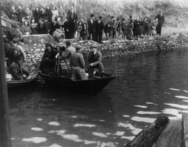 Set del film "Giacomo l'idealista" - Regia Alberto Lattuada - 1943 - Il regista Alberto Lattuada con attori non identificati e operatori in barca su un fiume