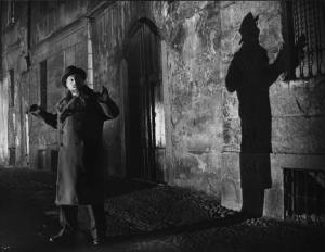 Scena del film "Il cappotto" - Regia Alberto Lattuada - 1952 - L'attore Giulio Stival per strada di notte con le mani in alto