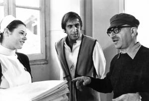 Set del film "Bianco, rosso e..." - Regia Alberto Lattuada - 1972 - Il regista Alberto Lattuada e l'attore Adriano Celentano sul set con un'attrice non identificata