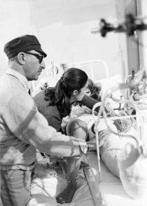 Set del film "Bianco, rosso e..." - Regia Alberto Lattuada - 1972 - Il regista Alberto Lattuada e l'attrice Tina Aumont sul letto in ospedale con un'operatrice