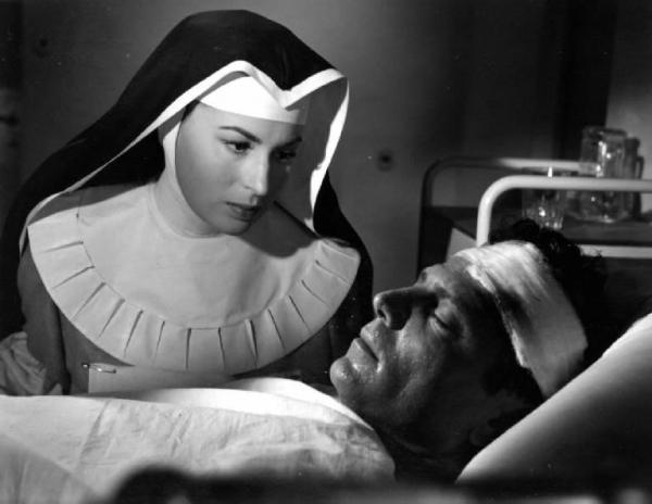 Scena del film "Anna" - Regia Alberto Lattuada - 1951 - L'attrice Silvana Mangano, in veste di suora infermiera, assiste Raf Vallone malato a letto
