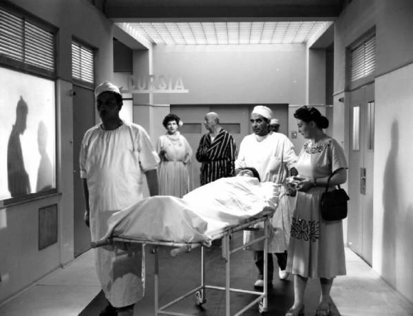 Scena del film "Anna" - Regia Alberto Lattuada - 1951 - Gli attori Emilio Petacci, Raf Vallone, in barella traspostato da due infermieri, e attori non identificati in ospedale
