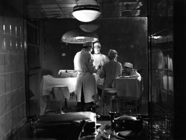 Scena del film "Anna" - Regia Alberto Lattuada - 1951 - Gli attori Jacques Dumesnil e Piero Lulli, in camice bianco in sala operatoria con attori non identificati in ospedale