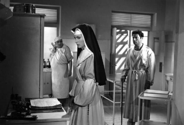 Scena del film "Anna" - Regia Alberto Lattuada - 1951 - Gli attori Silvana Mangano, in abito da suora infermiera, Raf Vallone, in vestaglia, e Paolo Ferrara, infermiere