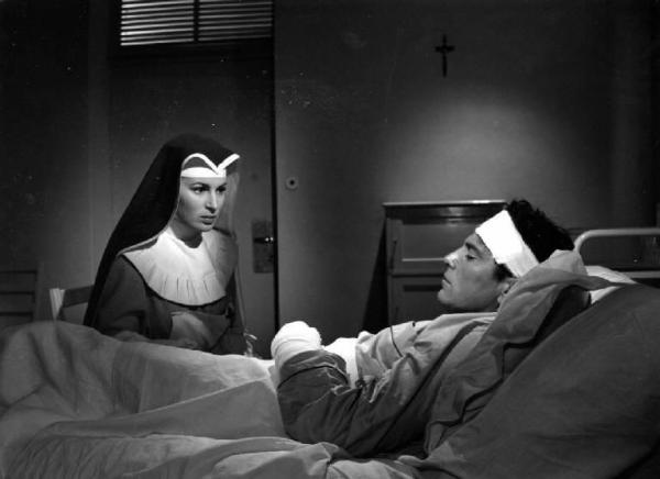Scena del film "Anna" - Regia Alberto Lattuada - 1951 - Gli attori Silvana Mangano, in abito da suora infermiera, e Raf Vallone, a letto in ospedale